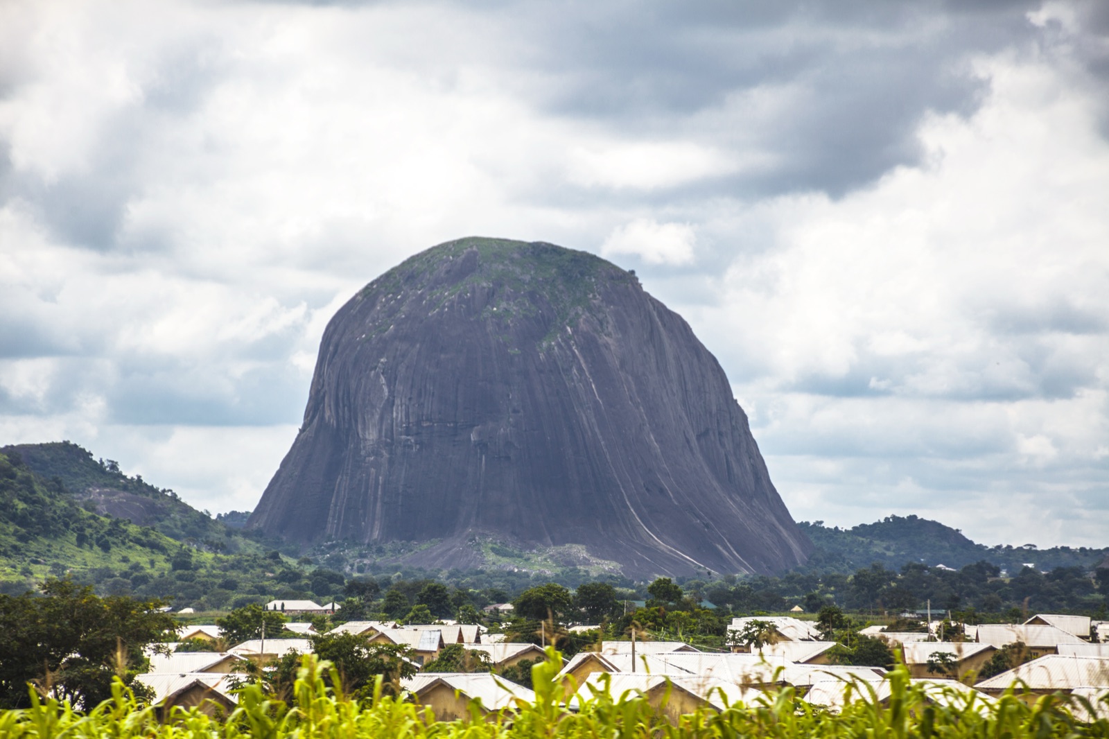 A rock outcrop rising above a town, representing the destinations covered by Voyageur24's ground transport service