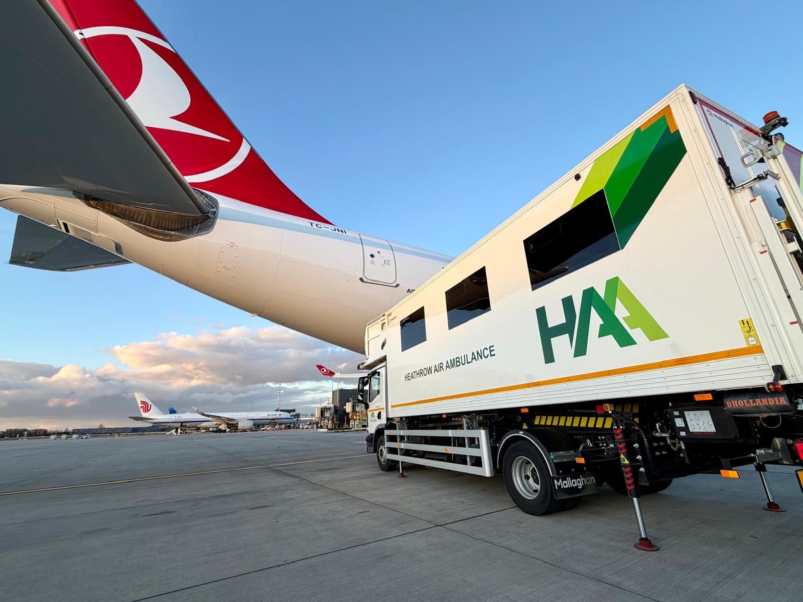 Airport assistance vehicle beside a passenger aircraft